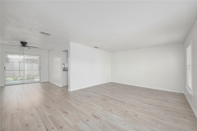 478 Orange Dr NW, Port Charlotte, FL 33952 - empty room with a textured ceiling, light wood-type flooring, ceiling fan, and baseboards