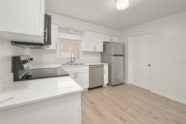 478 Orange Dr NW, Port Charlotte, FL 33952 - kitchen featuring appliances with stainless steel finishes, a sink, white cabinets, light wood finished floors, and a textured ceiling