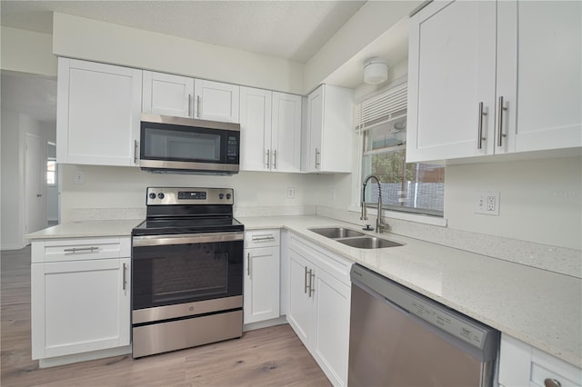 478 Orange Dr NW, Port Charlotte, FL 33952 - kitchen with stainless steel appliances, a sink, healthy amount of natural light, and white cabinets