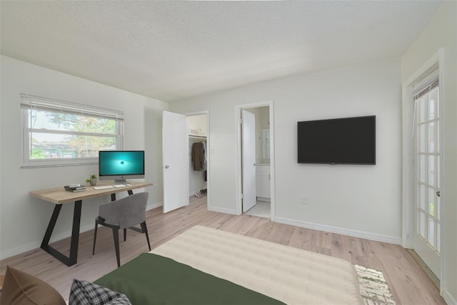 478 Orange Dr NW, Port Charlotte, FL 33952 - bedroom with light wood-style flooring, baseboards, a textured ceiling, and a spacious closet