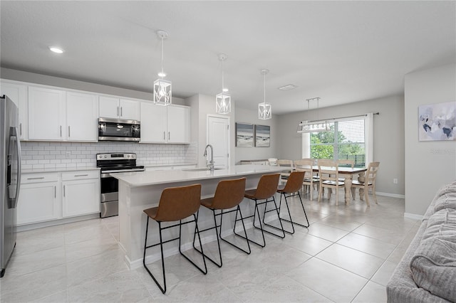 9148 Royal River Cir, Parrish, FL 34219 - kitchen with stainless steel appliances, a sink, decorative backsplash, light countertops, and a kitchen breakfast bar