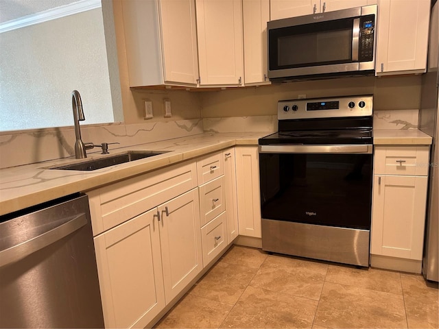 2650 Coconut Bay Ln Unit 521, Sarasota, FL 34237 - kitchen with appliances with stainless steel finishes, a sink, light countertops, and white cabinetry