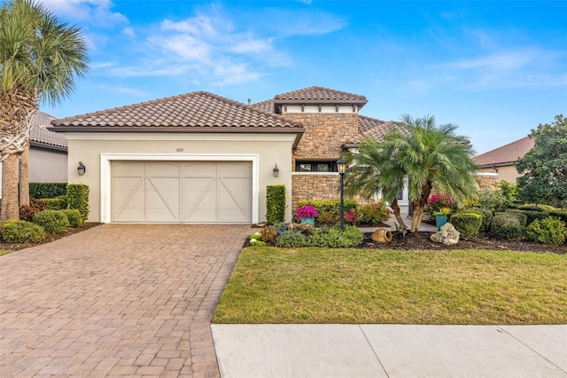 5011 Tivoli Run, Bradenton, FL 34211 - mediterranean / spanish home with driveway, stucco siding, stone siding, a garage, and a front lawn