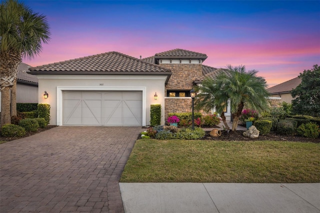 5011 Tivoli Run, Bradenton, FL 34211 - mediterranean / spanish-style house with decorative driveway, stucco siding, a garage, and a yard