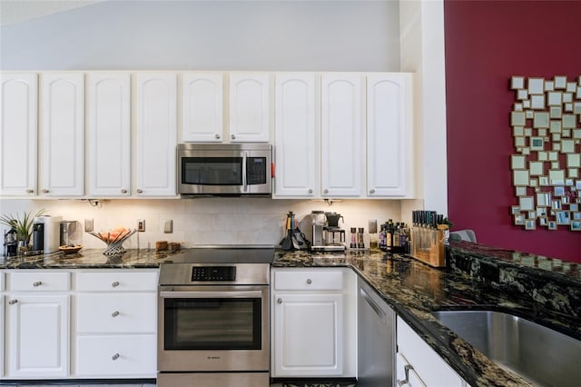 7155 Boca Grove Pl Unit 202, Lakewood Ranch, FL 34202 - kitchen featuring appliances with stainless steel finishes, white cabinets, dark stone countertops, and vaulted ceiling