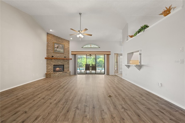 4622 34th Ct E, Bradenton, FL 34203 - unfurnished living room with a ceiling fan, wood finished floors, a fireplace, baseboards, and high vaulted ceiling