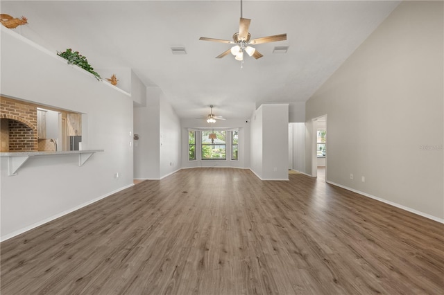 4622 34th Ct E, Bradenton, FL 34203 - unfurnished living room with ceiling fan, high vaulted ceiling, wood finished floors, baseboards, and a sink