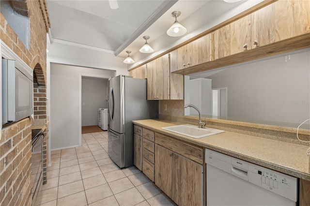 4622 34th Ct E, Bradenton, FL 34203 - kitchen with white dishwasher, a sink, washing machine and clothes dryer, crown molding, and light tile patterned floors