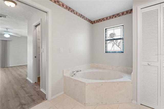 4622 34th Ct E, Bradenton, FL 34203 - full bathroom with a closet, a whirlpool tub, a ceiling fan, and baseboards