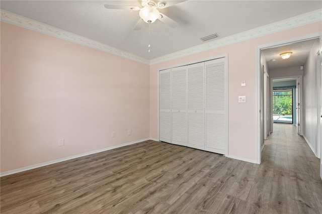 4622 34th Ct E, Bradenton, FL 34203 - unfurnished bedroom featuring wood finished floors, a closet, and baseboards