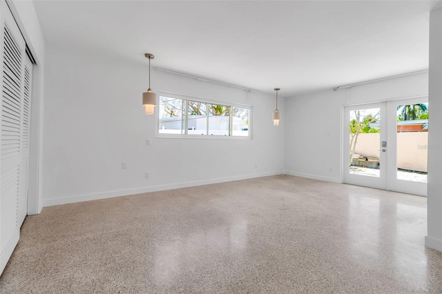 130 N Adams Dr, Sarasota, FL 34236 - empty room featuring healthy amount of natural light, speckle patterned floor, french doors, and baseboards