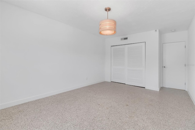 130 N Adams Dr, Sarasota, FL 34236 - unfurnished bedroom featuring a closet, baseboards, and speckle patterned floor