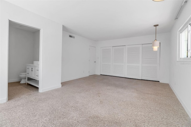 130 N Adams Dr, Sarasota, FL 34236 - unfurnished bedroom with connected bathroom, carpet flooring, and baseboards