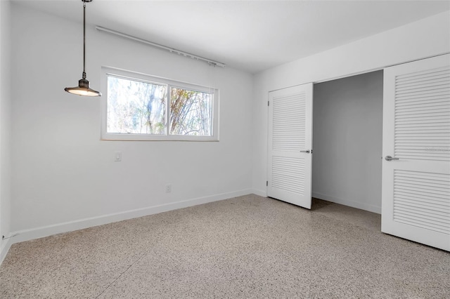 130 N Adams Dr, Sarasota, FL 34236 - unfurnished bedroom featuring speckle patterned floor, baseboards, and a closet