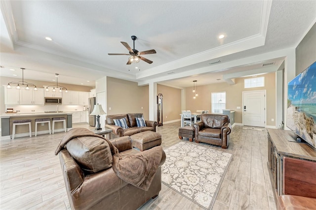 1219 Thornbury Dr, Parrish, FL 34219 - living area featuring a raised ceiling, light wood-type flooring, a ceiling fan, a textured ceiling, and baseboards
