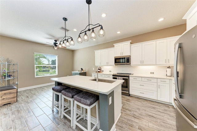 1219 Thornbury Dr, Parrish, FL 34219 - kitchen with stainless steel appliances, a sink, a ceiling fan, light countertops, and white cabinets