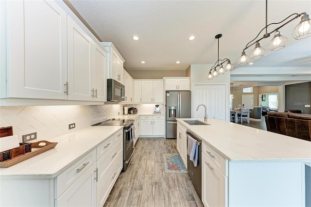 1219 Thornbury Dr, Parrish, FL 34219 - kitchen featuring appliances with stainless steel finishes, a sink, white cabinets, a large island with sink, and recessed lighting