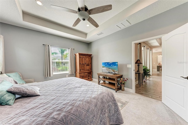 1219 Thornbury Dr, Parrish, FL 34219 - bedroom with a raised ceiling, light carpet, ceiling fan, recessed lighting, and a textured ceiling