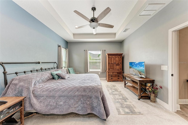 1219 Thornbury Dr, Parrish, FL 34219 - bedroom featuring a tray ceiling, light carpet, ceiling fan, and baseboards