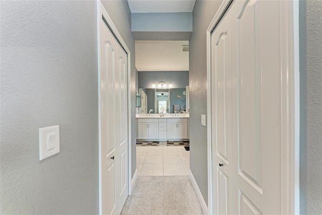 1219 Thornbury Dr, Parrish, FL 34219 - corridor featuring tile patterned floors, baseboards, carpet floors, and a textured wall