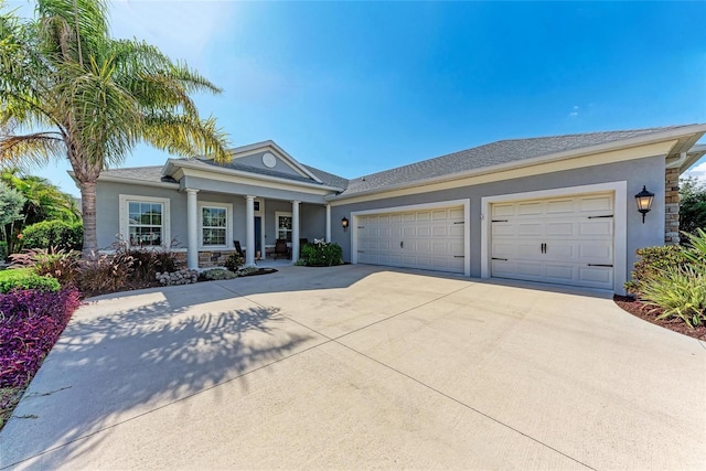 1219 Thornbury Dr, Parrish, FL 34219 - view of front facade featuring driveway, stucco siding, an attached garage, and covered porch