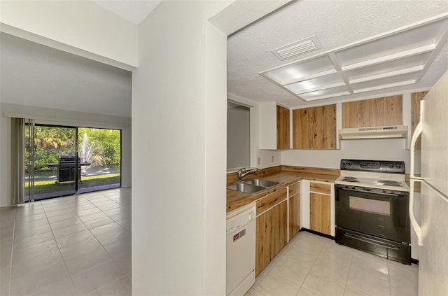 933 Sunridge Way Unit B5, Sarasota, FL 34234 - kitchen with white appliances, under cabinet range hood, and light tile patterned flooring