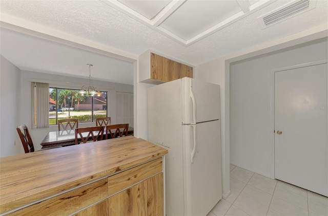 933 Sunridge Way Unit B5, Sarasota, FL 34234 - kitchen with freestanding refrigerator, light tile patterned floors, a chandelier, wooden counters, and hanging light fixtures
