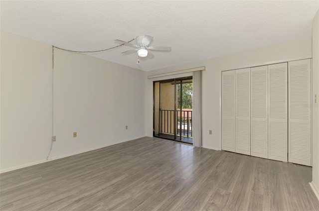 933 Sunridge Way Unit B5, Sarasota, FL 34234 - unfurnished bedroom featuring access to outside, light wood-style floors, a textured ceiling, ceiling fan, and a closet