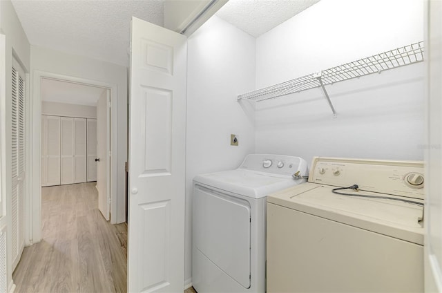 933 Sunridge Way Unit B5, Sarasota, FL 34234 - washroom featuring washing machine and clothes dryer, light wood-style floors, and a textured ceiling