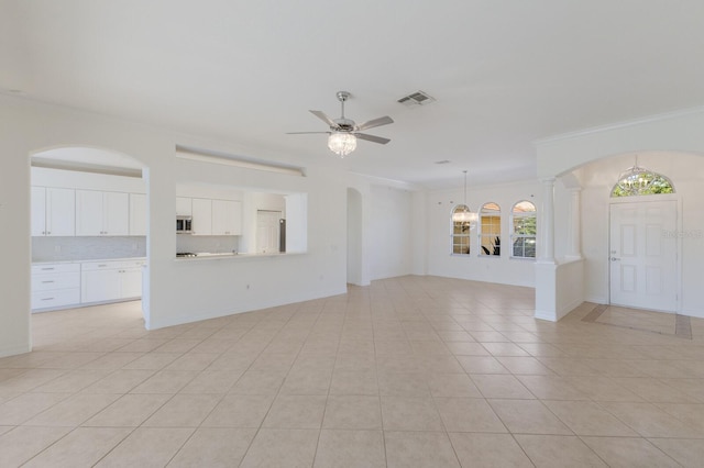 9719 Discovery Ter, Bradenton, FL 34212 - unfurnished living room with ornamental molding, light tile patterned floors, ceiling fan, arched walkways, and ornate columns