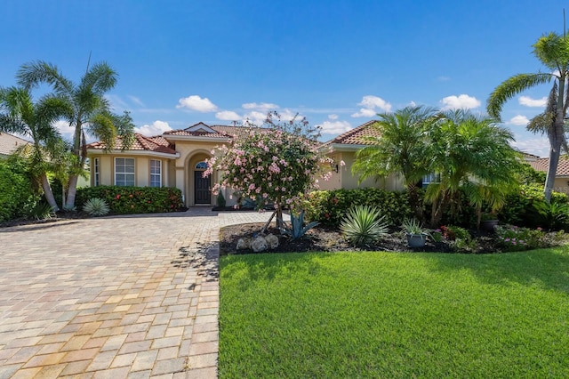 9719 Discovery Ter, Bradenton, FL 34212 - mediterranean / spanish house featuring stucco siding, decorative driveway, a front yard, and a tile roof