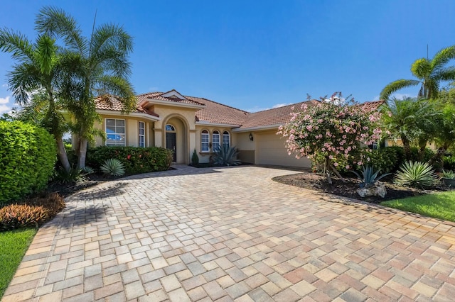 9719 Discovery Ter, Bradenton, FL 34212 - mediterranean / spanish-style home with decorative driveway, stucco siding, an attached garage, and a tiled roof