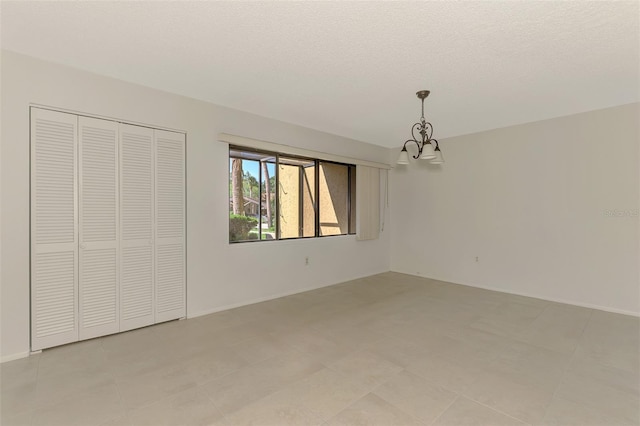 935 Sunridge Way Unit B4, Sarasota, FL 34234 - unfurnished bedroom with a chandelier, a closet, and a textured ceiling