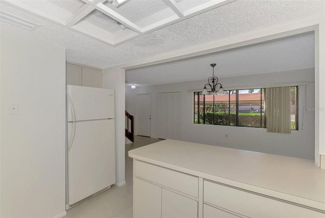 935 Sunridge Way Unit B4, Sarasota, FL 34234 - kitchen with freestanding refrigerator, light countertops, decorative light fixtures, a chandelier, and a textured ceiling