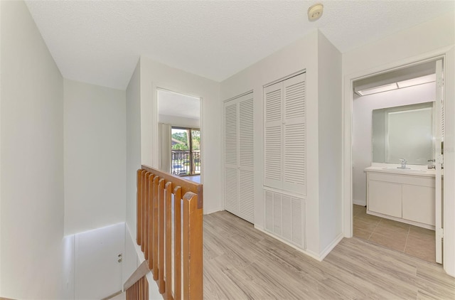 935 Sunridge Way Unit B4, Sarasota, FL 34234 - corridor featuring light wood-type flooring and an upstairs landing