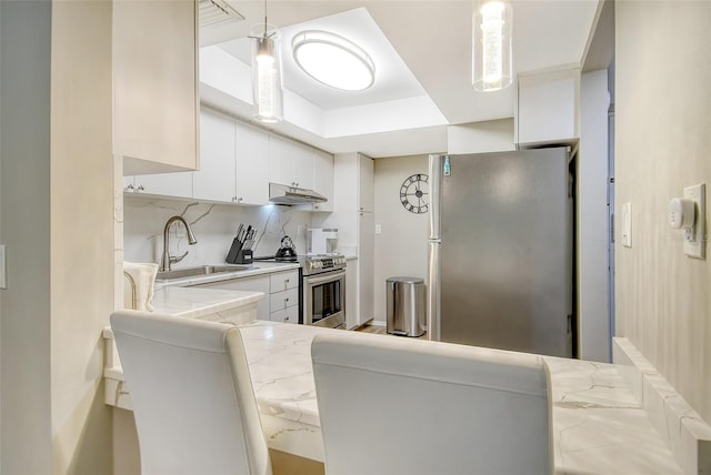 2055 Gulf Of Mexico Dr Unit G2-108, Longboat Key, FL 34228 - kitchen featuring appliances with stainless steel finishes, under cabinet range hood, white cabinets, backsplash, and decorative light fixtures