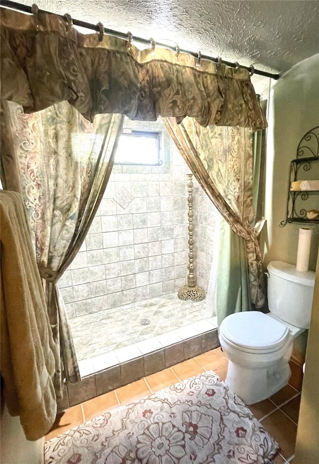 4042 S Lockwood Ridge Rd, Sarasota, FL 34231 - bathroom with toilet, a tile shower, tile patterned floors, and a textured ceiling