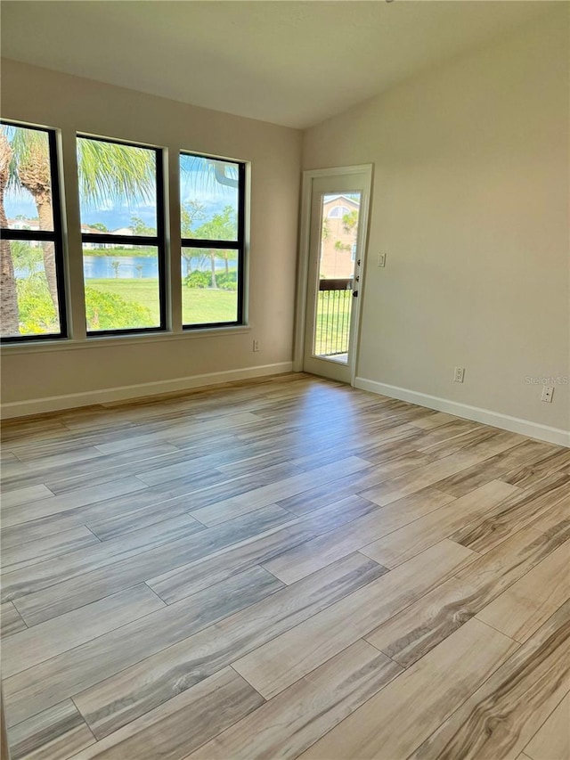 4037 Crockers Lake Blvd Unit 24, Sarasota, FL 34238 - spare room with light wood-style flooring, baseboards, and a water view