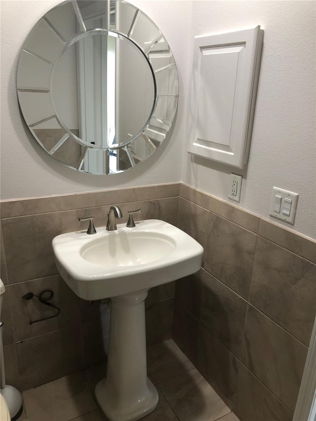 4037 Crockers Lake Blvd Unit 24, Sarasota, FL 34238 - bathroom with tile walls, a wainscoted wall, a sink, and toilet