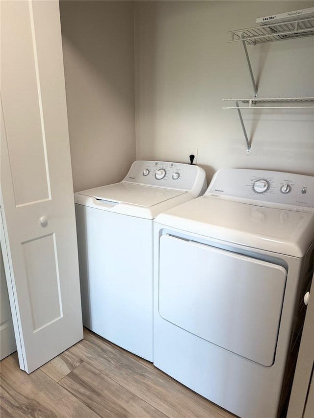 4037 Crockers Lake Blvd Unit 24, Sarasota, FL 34238 - laundry room with washer and clothes dryer and light wood-style flooring