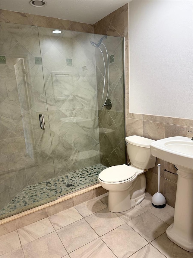 4037 Crockers Lake Blvd Unit 24, Sarasota, FL 34238 - bathroom featuring a stall shower, tile walls, toilet, a wainscoted wall, and tile patterned floors