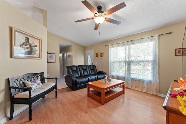 712 68th Ave W, Bradenton, FL 34207 - living area featuring ceiling fan, vaulted ceiling, light wood-style flooring, a textured ceiling, and baseboards