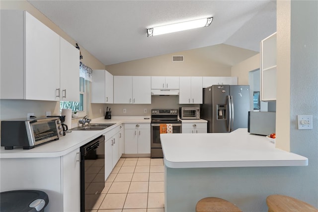 712 68th Ave W, Bradenton, FL 34207 - kitchen with appliances with stainless steel finishes, under cabinet range hood, a peninsula, white cabinetry, and vaulted ceiling