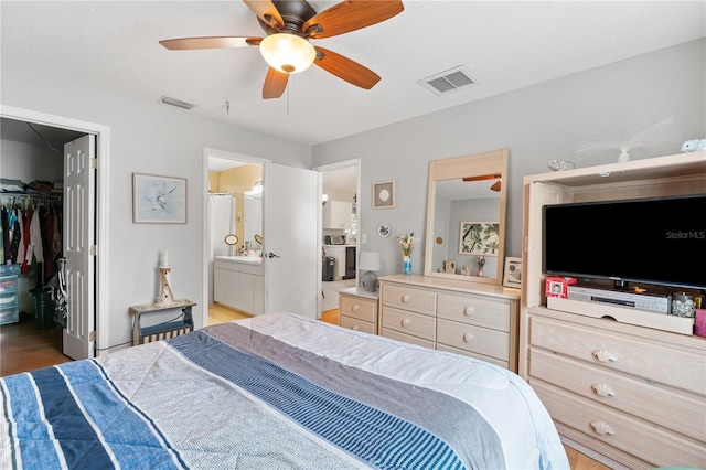 712 68th Ave W, Bradenton, FL 34207 - bedroom featuring a spacious closet, wood finished floors, a closet, connected bathroom, and a ceiling fan