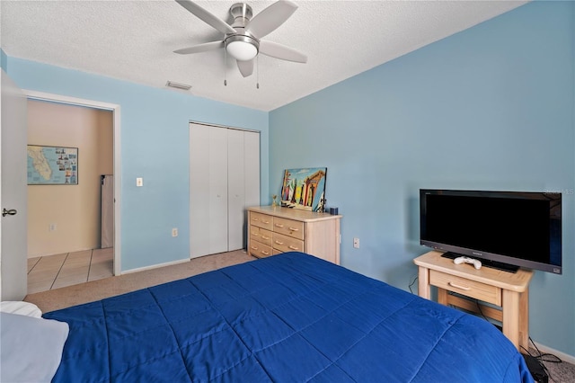 712 68th Ave W, Bradenton, FL 34207 - bedroom featuring light carpet, a ceiling fan, a closet, a textured ceiling, and baseboards