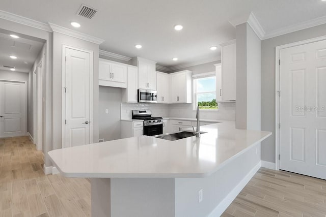 3204 Torta Ct, Bradenton, FL 34211 - kitchen with appliances with stainless steel finishes, light wood-type flooring, tasteful backsplash, a peninsula, and ornamental molding