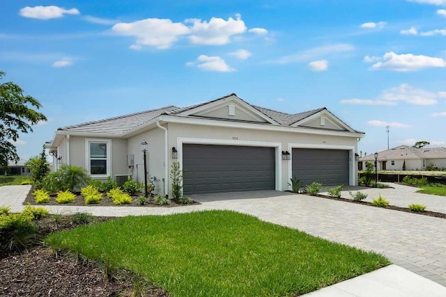 3204 Torta Ct, Bradenton, FL 34211 - ranch-style home featuring an attached garage, stucco siding, decorative driveway, a tile roof, and a front yard