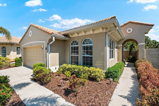138 Tiziano Way N, Venice, FL 34275 - mediterranean / spanish-style house with stucco siding, an attached garage, driveway, and a tile roof