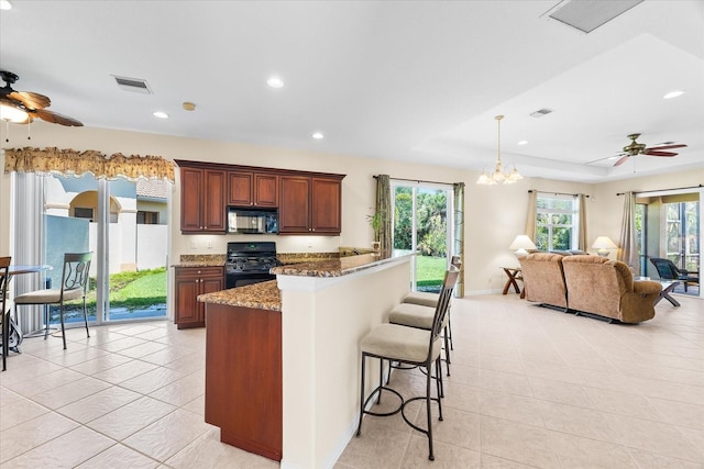 138 Tiziano Way N, Venice, FL 34275 - kitchen featuring black appliances, a ceiling fan, a breakfast bar, stone counters, and recessed lighting
