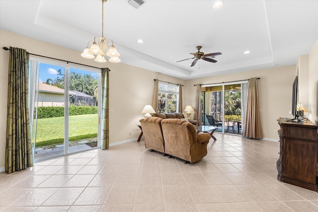 138 Tiziano Way N, Venice, FL 34275 - living room featuring a raised ceiling, baseboards, a ceiling fan, light tile patterned floors, and a chandelier